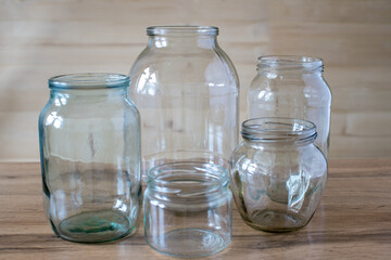 Glass jars of different sizes and volumes on the wooden table.
