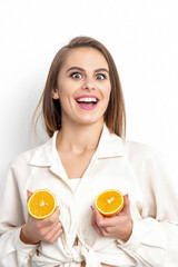 Joyful attractive young woman having two pieces of orange isolated on white background with copy space