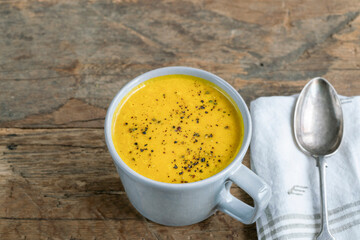 mug bowl of soup on wooden table