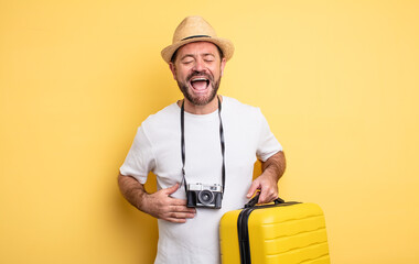 middle age man tourist laughing out loud at some hilarious joke. travel concept