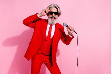 Portrait of attractive trendy talented cheery grey-haired man mc showman singing hit isolated over...