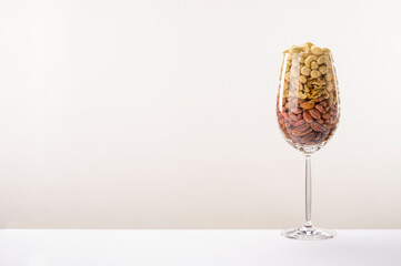 Glass jar filled with a variety of nutrition and healthy snacks and nuts on a white background