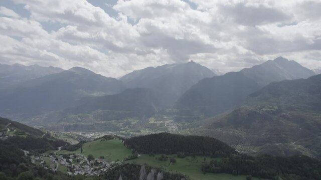 plane moving forward with drone over the aosta valley in saint nicolas with the church of fonfo and over a winding road