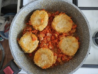 Cutlets with vegetables are stewed in a pan