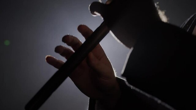 Close up hands playing the duduk on black background 4K. Man playing classical music