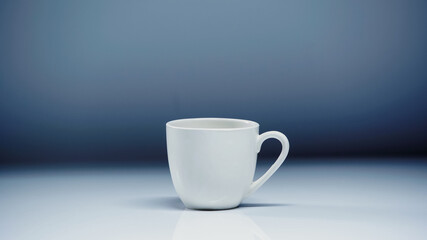white cup with coffee on white surface on grey background.