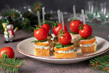 Festive canapes with croutons, smoked chicken, cheese and cherry tomatoes on new year brown background