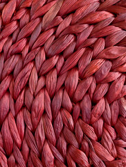 Banana leaf braids in dark red. Wicker background. The texture of braiding around the circle.