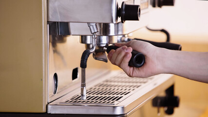 partial view of barista putting coffee filter holder.