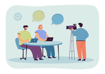 Fototapeta na wymiar Cartoon operator shooting news reportage in studio. Cameraman filming TV presenters sitting at table flat vector illustration. Television, broadcasting concept for banner or landing web page