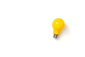 Yellow lightbulb against white background. Creativity, innovation, inspiration, imaginativeness or cleverness concept. Top view, flat lay, copy space.