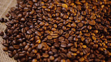 high angle view of roasted and fresh coffee beans on canvas.