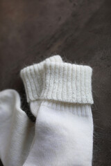 White knitted natural wool socks on a beige and gray table. Hand-knitted products.
