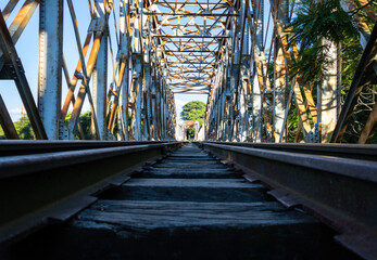 Bridge over a river on the train tracks with lush railroad tracks in an unexplored nature. Mention to travel, tourism, exploration, railways, entertainment and new places.