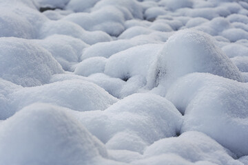 Round rocks near river covered with layer of snow