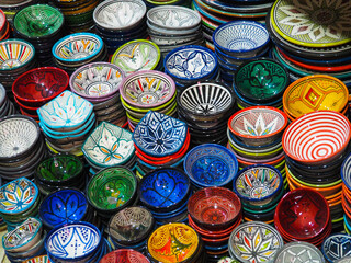 Handmade colourful decorated bowls or cups on display at traditional souk - street market in Morocco