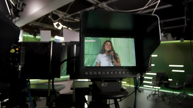 TV presenter woman tells the news. Studio backstage video recording. Camera with commutation equipment for broadcasting or media production
