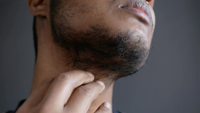 young man checking his beard close up 