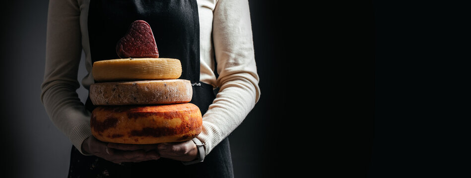 various types of cheese in femele hands. Long banner format