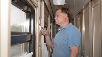 An adult man reads the instructions for emergency braking of a train using a stop crane..