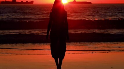 Pretty Asian woman enjoys a walk on the beach at sunset. Slow Motion.