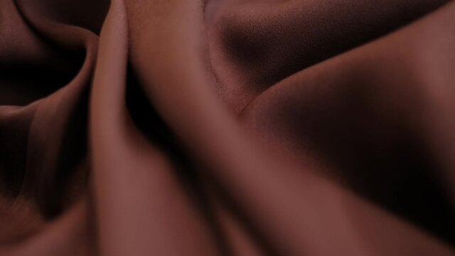 closeup the motion footage vide. brown Textile abstract background. Clothing industry concept. Wavy material. velours fabric threads macro. Side view. Close-up shooting stock footage