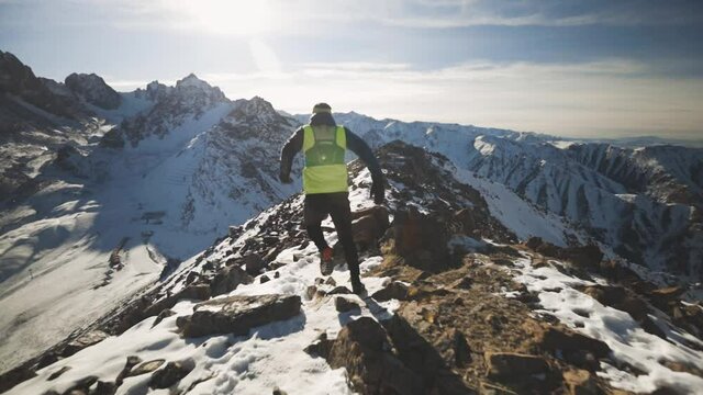 Man running at the mountain with snow
