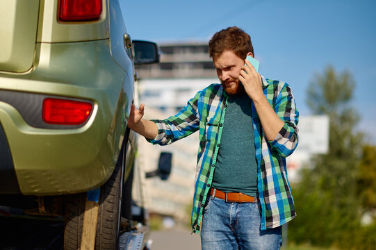 Man driver discussing occurrence by mobile phone