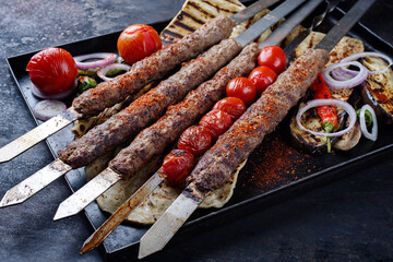 Traditional Turk Adana kebap on shashlik skewer with barbecue vegetable, flatbread and yogurt as...