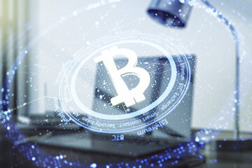 Double exposure of creative Bitcoin symbol with modern laptop on background. Cryptocurrency concept