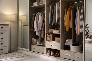 Wardrobe closet with different stylish clothes, shoes and home stuff in room - obrazy, fototapety, plakaty