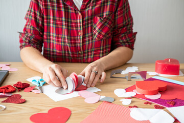 DIY holiday card with red paper heart, symbol of love. Girl  makes Mother's Day, Valentine's Day, greeting card. Hobby,  art concept, gift with your own hands. Happy Valentine Day. Valentines day back