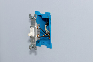 White electrical light switch and wiring in wall. DIY home maintenance, remodeling and electricity...