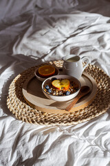 Müsli in einer Schüssel mit frischen Obst und Milch auf einem Holz Serviertablett auf einer...