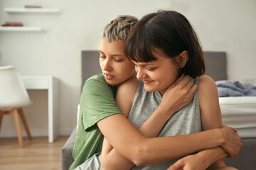 Young lesbian couple resting and hugging at home