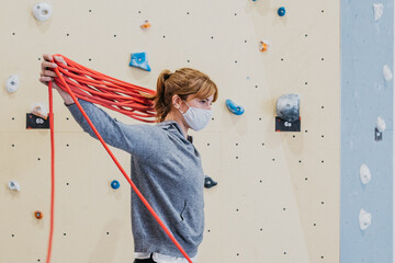 Woman in medical mask with ropes for climbing