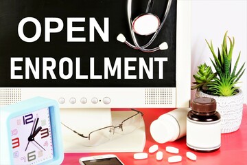 Open enrollment. The inscription on the monitor screen against the background of medicines and a...