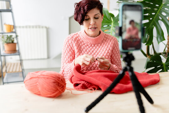 Woman recording video with knitted sweater