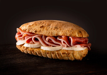 Sandwich with mozzarella and cured raw ham on dark background - 477324578