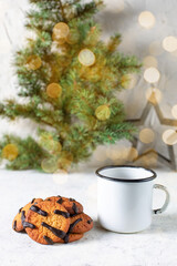 orange cookies with black stripes and cup of tea with fir tree branch. Christmas dessert. Concept for children new year