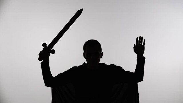 Medieval warrior with a sword raised his hands up