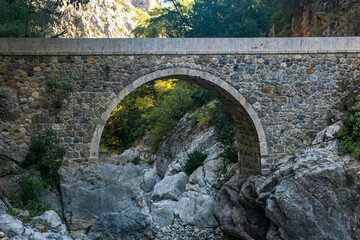 ancient Roman bridge over a shady gorge in the Kesme Bogazi canyon, Turkey