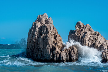 sea coastal cliffs among surf on a windy sunny day