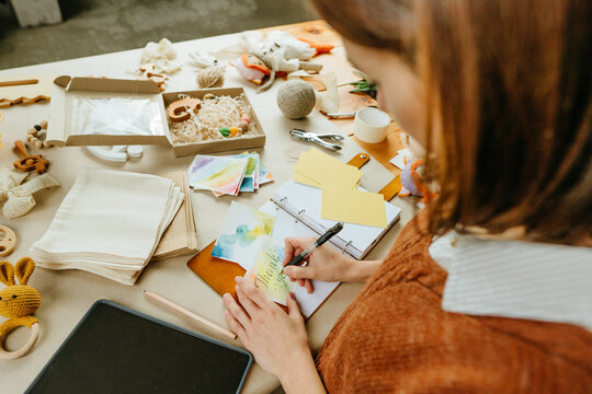 Young woman working at her workshop of handmade eco kids toys
