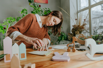 Young woman putting a stamp on a linen bag packing purchase