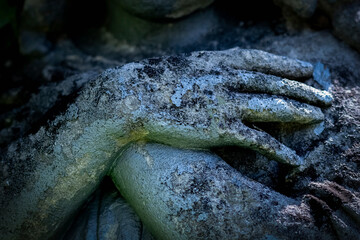 Close up praying angel folded his arms across his chest Fragment of a very ancient stone statue.