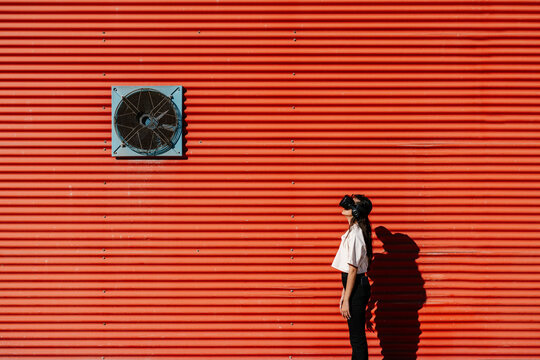 Woman using virtual reality simulator on sunny day