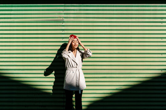 Young woman with head in hands on sunny day