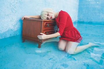 Depressed woman with eyes closed leaning on dresser in swimming pool