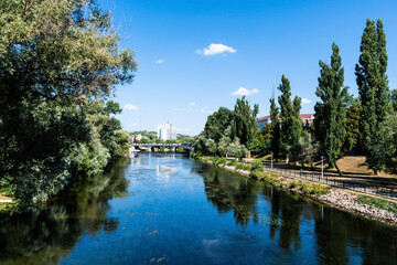 Fototapeta na wymiar View from Intellectuals bridge (podul Paralelor sau Intelectualilor) with Crisul Repede river, Dacia bridge and Continental Forum Hotel. Oradea, Romania.